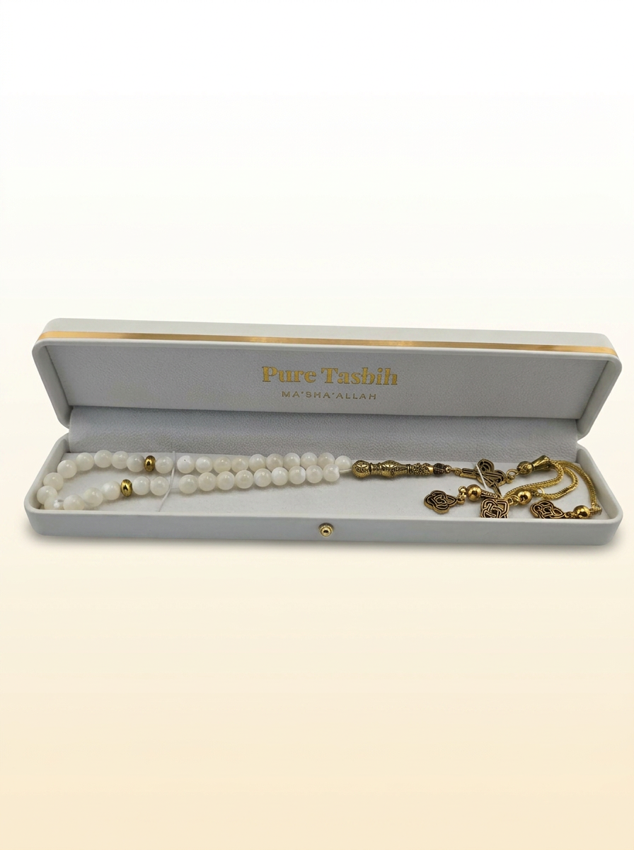 Pure Tasbih presentation box in ivory with gold foil logo, white beads and ornate gold tassel on a clean cream background
